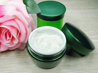 cosmetic cream for face care and rose flowers