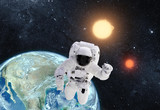 Fototapeta Kosmos - Astronaut in outer space over the planet earth. This image is a collage of different images furnished by NASA