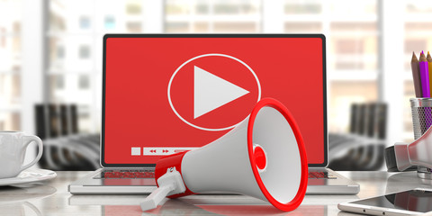 Poster - megaphone, bullhorn and video player on a computer screen. blurred office background, close up view.