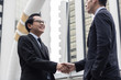 © khwanchai - Successful negotiating business concept, Businessmen shaking hands after finishing meeting or setting  goals and planning way to success in front of building .
