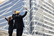 © khwanchai - Hand coordination of team businesswoman and engineering on sky infront of bank building, office after successful project.