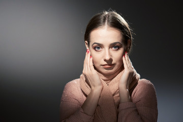 Wall Mural - beautiful girl in pink knitted sweater. emotional portrait on a dark background.