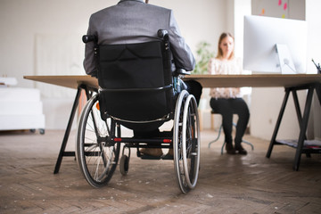 Wall Mural - Two business people with wheelchair in the office.