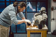 © Kzenon Premium - Stonework conservator working on preservation of historical piece