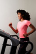 © mimagephotos - Healthy african girl running on treadmill in gym