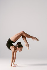 Wall Mural - Young gymnast girl stretching and training