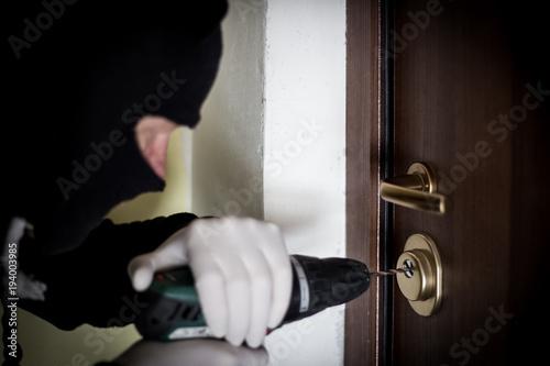 Crime Robbery Masked Thief Burglar Trying To Break Into A Flat Crime Robbery Masked Thief Burglar Trying To Break Into A Flat Drill In The Hands