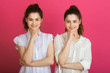 © Alexandr - two beautiful young sisters twin girls with a smile on a pink background
