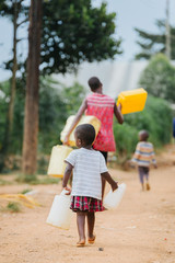child carrying water cans in uganda africa