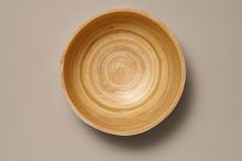 Empty Wooden Bamboo Bowl Isolated On Grey Background With Real Shadow. Top View With Copy Space For Text Or Image
