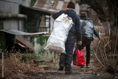Cuadros en Lienzo Poor people with bags of garbage outdoors