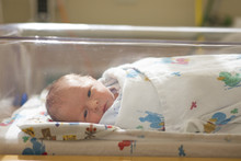 Close Up Of Newborn Baby In Hospital Crib