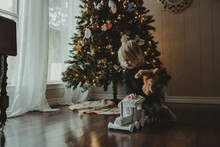 Girl Playing With Toys Against Christmas Tree At Home
