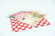 Banknoty EURO w czerwonej kopercie w białe kropki