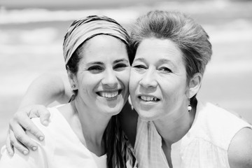 Wall Mural - Portrait of two beautiful 45 years old women walking on seaside