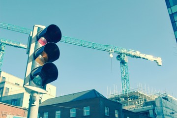 Red lignt with construction crane in the background. Vintage.