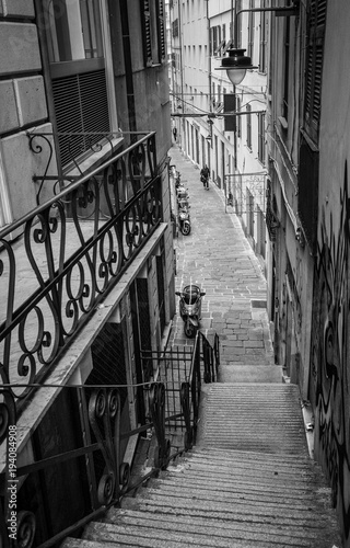 black-and-white-photo-of-old-narrow-crowdless-streets-of-the-old-genova-district-in-genoa-italy