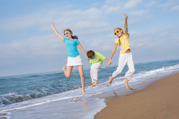 Poster - Three happy children running on the beach at the day time.