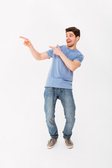 Wall Mural - Full-length photo of splendid man rejoicing and pointing fingers aside meaning hey you, isolated over white background