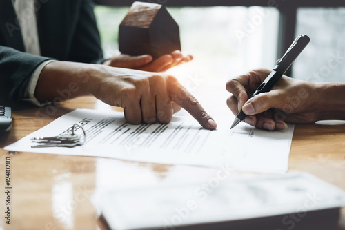 Fotografía Businessman and estate agent signing a document for house deal, vintage filter e