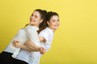 © Alexandr - two beautiful joyful sisters twin girls in white blouses on a yellow background