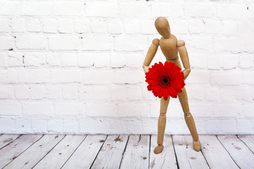 Wall Mural - Wooden mannequin with red gerbera flower