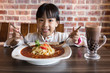 Leinwandbild Motiv Asian Chinese little girl eating spaghetti bolognese