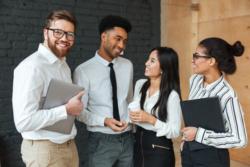 Wall Mural - Happy young business colleagues talking with each other.