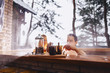 Couple drinking hot tea while sitting in the winter outside hot spa
