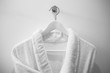 White robe on the hanger in the bathroom.