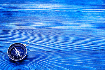 Wall Mural - Compass on blue wooden background top view copy space