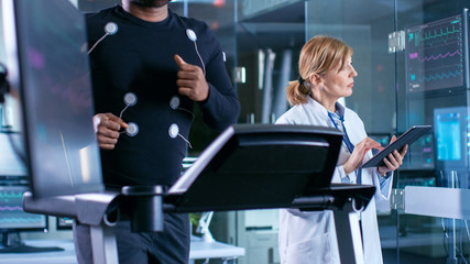 Wall Mural - monitor shows ekg reading of a male athlete running on a treadmill in the background, specialist sup