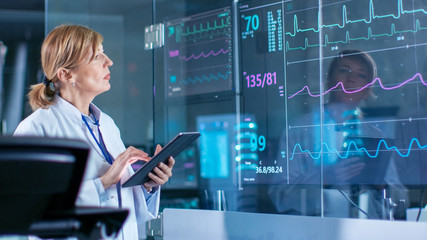 Wall Mural - sport scientist holds tablet and supervises ekg status. laboratory with high-tech equipment.