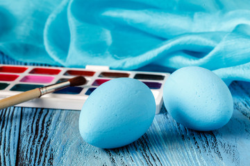 Wall Mural - Painted easter eggs on blue wooden table