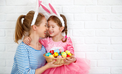 happy easter! family mother and child daughter with ears hare getting ready for holiday