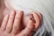 Closeup senior woman with hearing aid in her ear. Health care, hear amplify, device for the deaf.