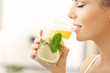 © Africa Studio - Beautiful young woman drinking fresh lemonade at home, closeup