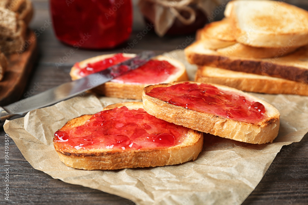 Delicious toasts with sweet jam on wooden table