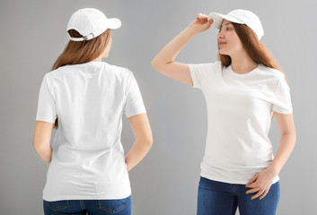 Wall Mural - Front and back views of young woman in stylish t-shirt and cap on grey background. Mockup for design