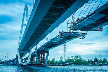 Construction of a bridge across the river. The long bridge. Metal structures. High bridge. Highway construction.