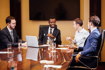 company black leader at business presentation table with attention from staff