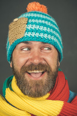 Wall Mural - Smiling handsome bearded man, sexy guy in knitted hat and scarf. Winter fashion. Brutal caucasian hipster, bearded man with long beard, with beard and moustache wearing hat and scarf.