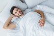 © LIGHTFIELD STUDIOS - top view of cheerful man lying on bed in the morning