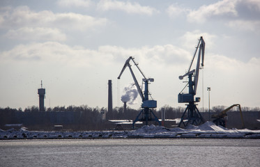 Logistics and transportation  Cargo ship with ports crane bridge coming in port and transportation industry winter suny day in Latvia baltic sea an river daugava.