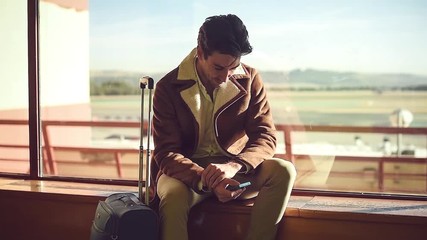 handsome man using phone in airport