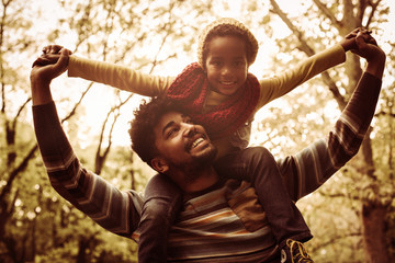 Wall Mural - African American father with daughter on meadow.