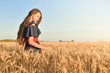© xzgorik - Young girl standing in the field and admiring the wheat flakes