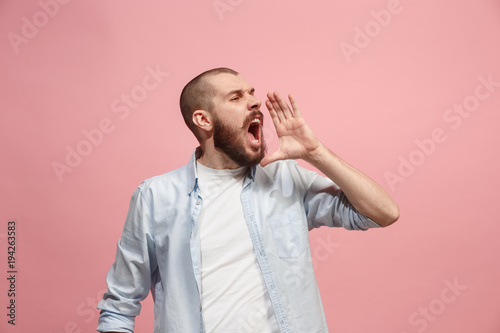 Fotomural Isolated on pink young casual man shouting at studio