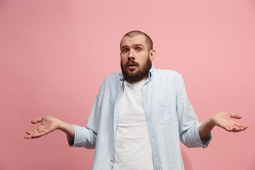 Wall Mural - Let me think. Doubtful pensive man with thoughtful expression making choice against pink background