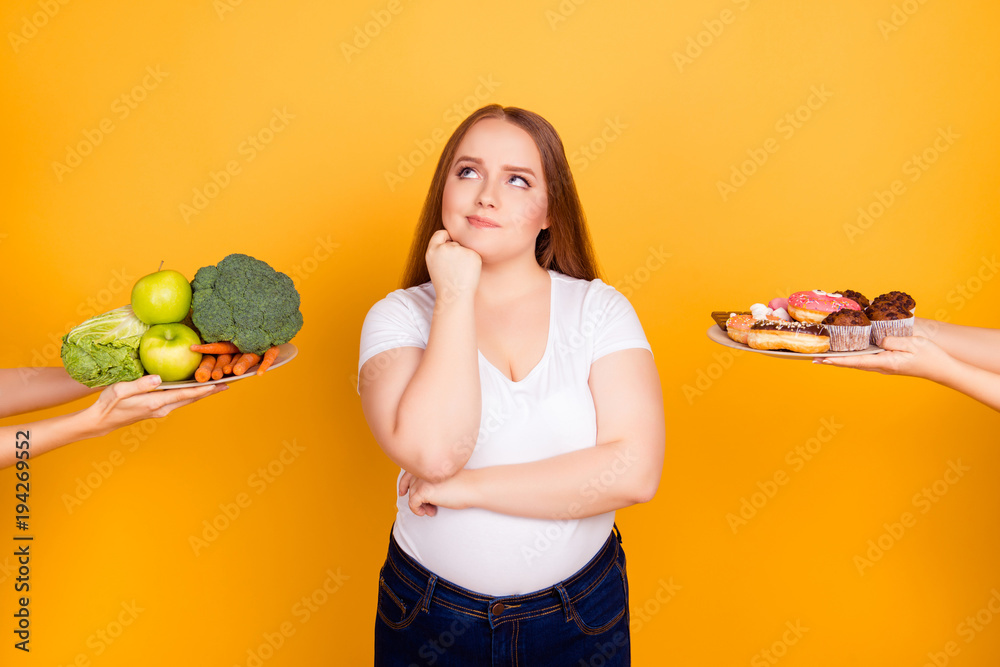 Young woman making choice between healthy and unhealthy food - obrazy, fototapety, plakaty 